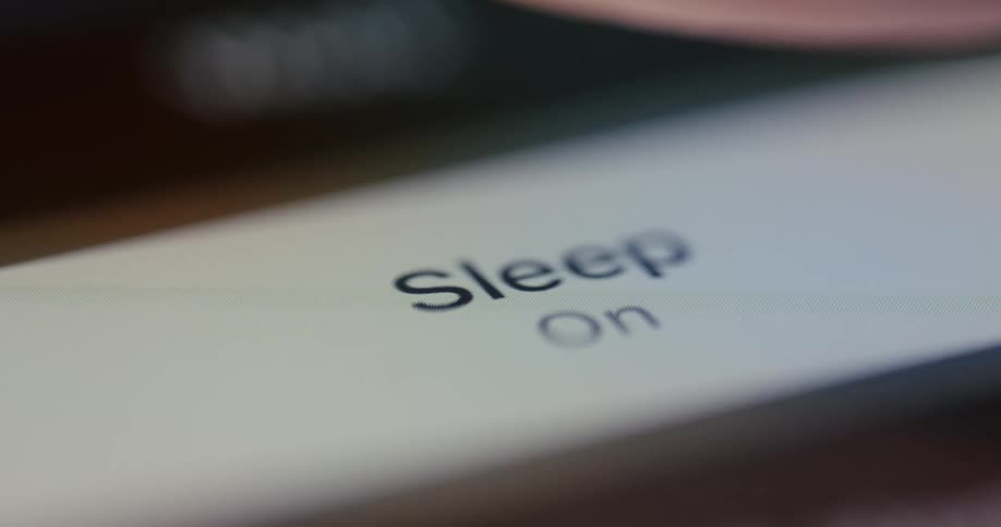 Close up of a finger pressing a digital button with the word sleep on it
