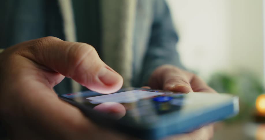 Closeup of a persons hands holding and operating a smartphone and then putting it in their pocket
