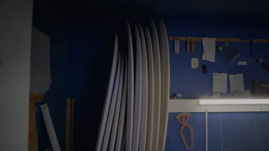 Surfboards of different sizes leaning against a wall
