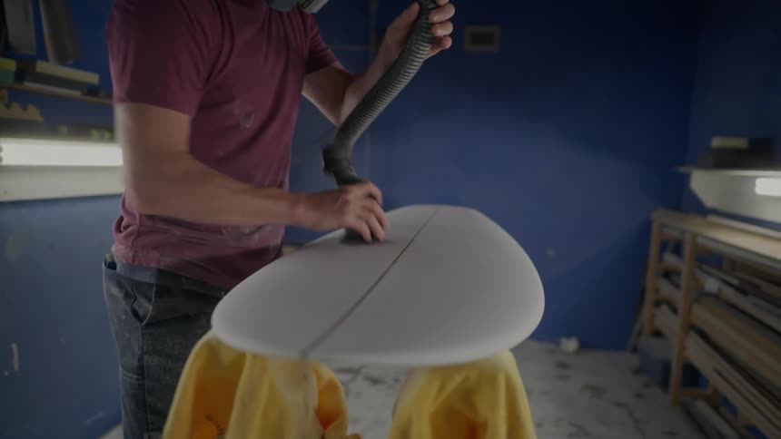 Man polishing a surfboard