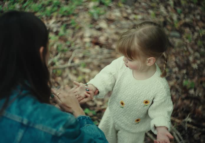 A mother brushes her daughters hand while theyre in nature