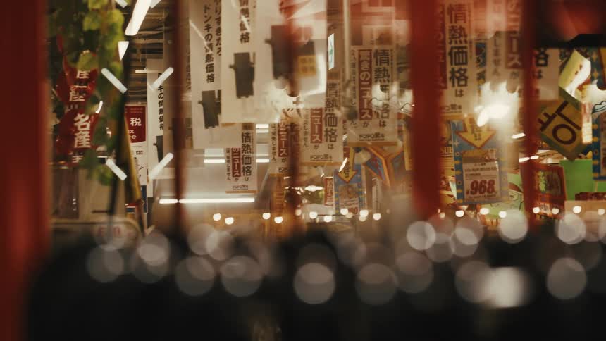 Night scene of an urban street lit by Japanese signs and banners in a Tokyo market