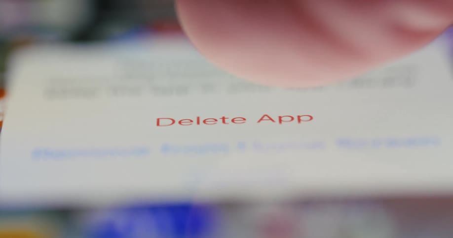 Extreme closeup of a finger deleting an app on the iphone
