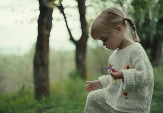 Mother and her children enjoy picking flowers outdoors