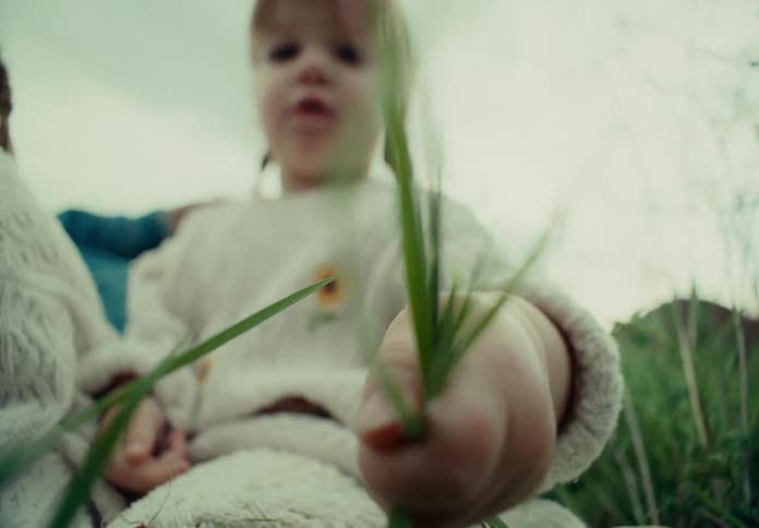 Children play with blades of grass