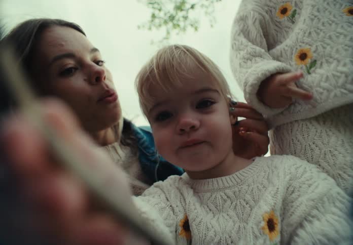 A mother and her daughters wearing thick sweaters and clothes taking a selfie