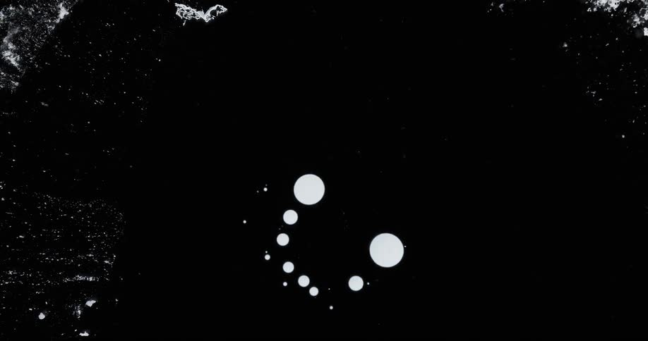 White polka dots with abstract pigmentation against a black background