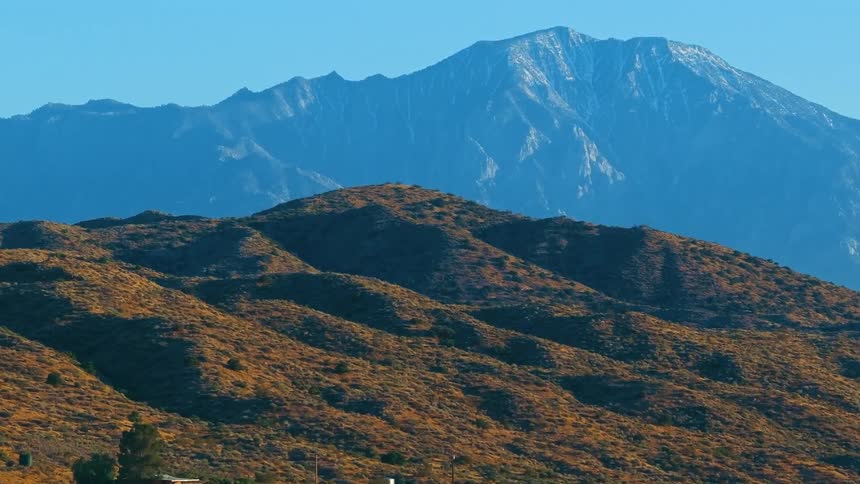 The last bit of snow on the spring mountains under a bright blue sky