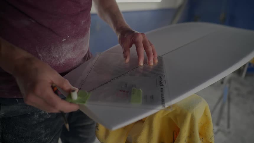 A person is using a tool with markings to measure a white board