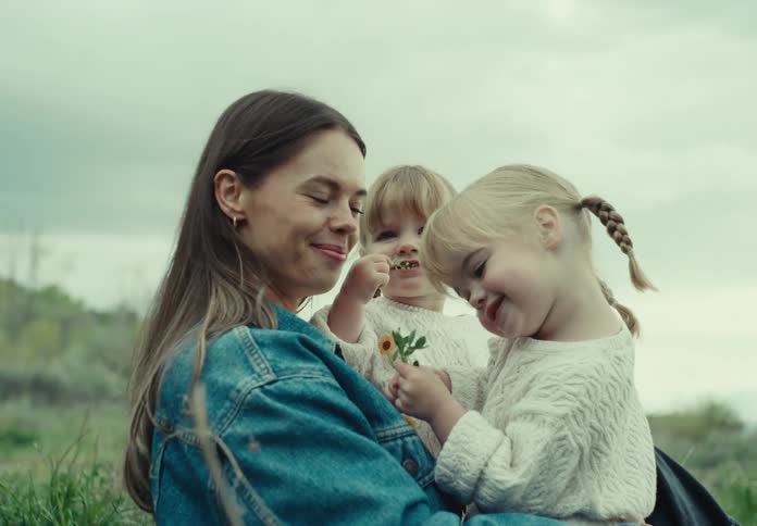 A mother holds her daughters on the field