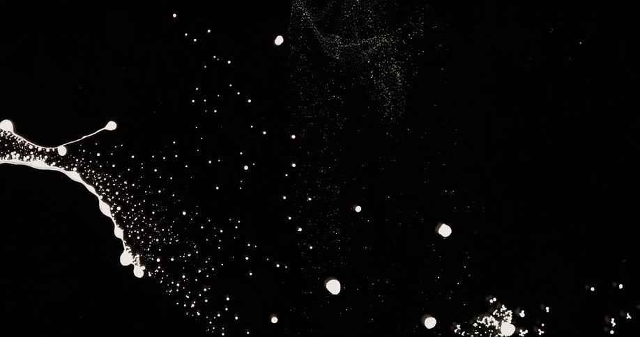 Microscopic view of an abstract white liquid in motion against a black background