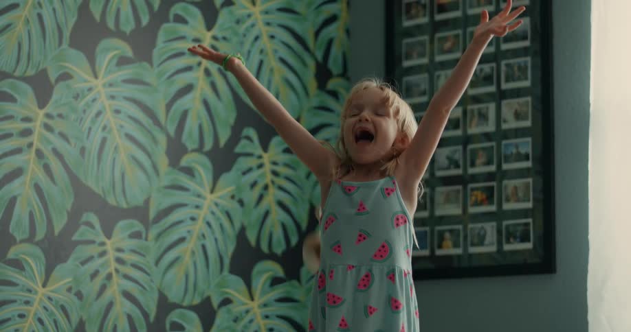 Little girl throwing teddy bears in the air smiling