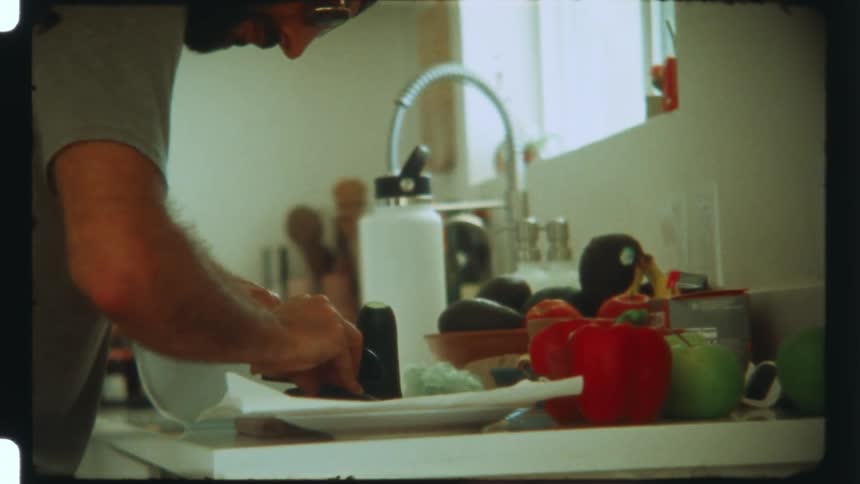 A man is cutting vegetables in the kitchen
