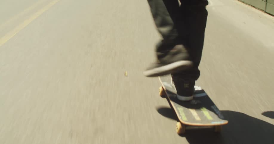 Man riding a skateboard on a busy street with vehicle and pedestrian traffic in a metropolis