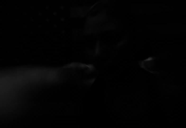 Sped up black and white footage of a woman boxing in front of an american flag