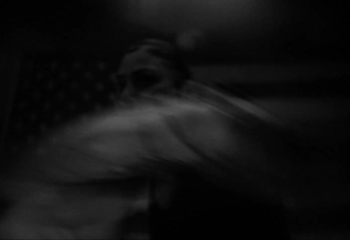 Black and white close up of a woman boxing in front of an american flag