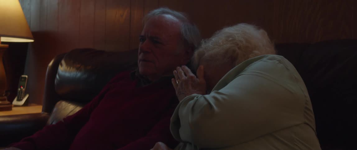 Elderly couple watching a scary show together while talking