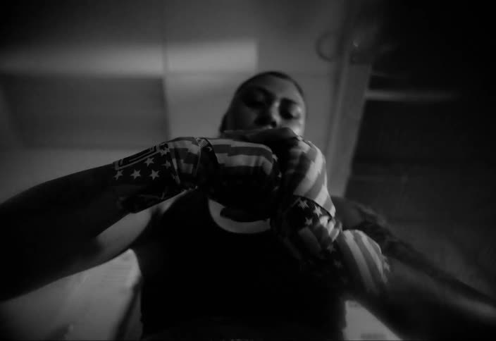 A female hispanic boxer in a gym rubbing her taped hands together