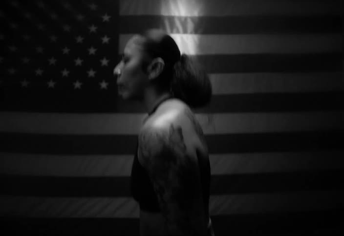A woman jumps up and down in front of the flag