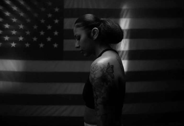 Concentrated boxer woman with the flag of the united states in the background
