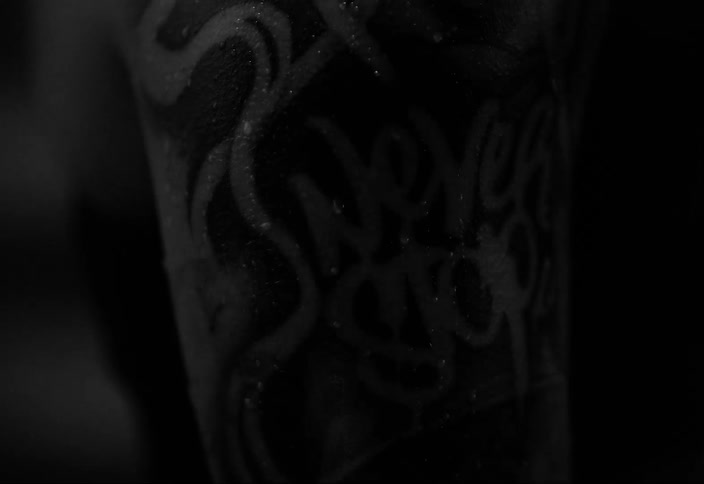 A light steadily flashes on a bare arm covered in a tattoo