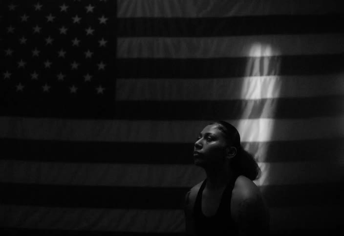 Woman sitting looking up with an american flag in the background