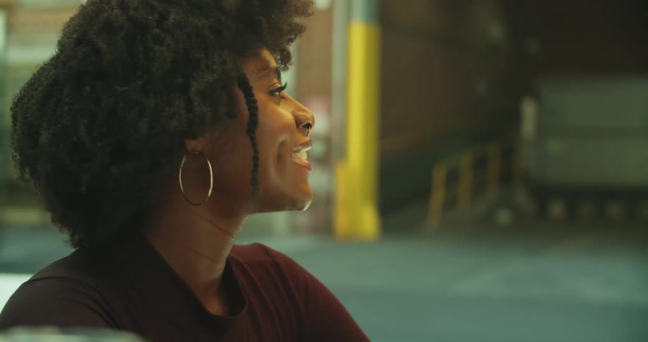 A young woman smiles and laughs while talking to someone