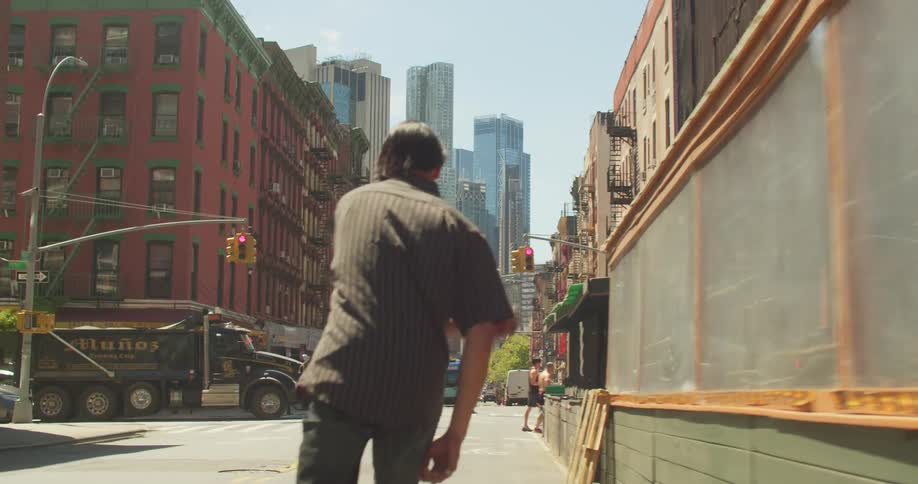 Young man riding a skateboard on the street of a busy metropolis