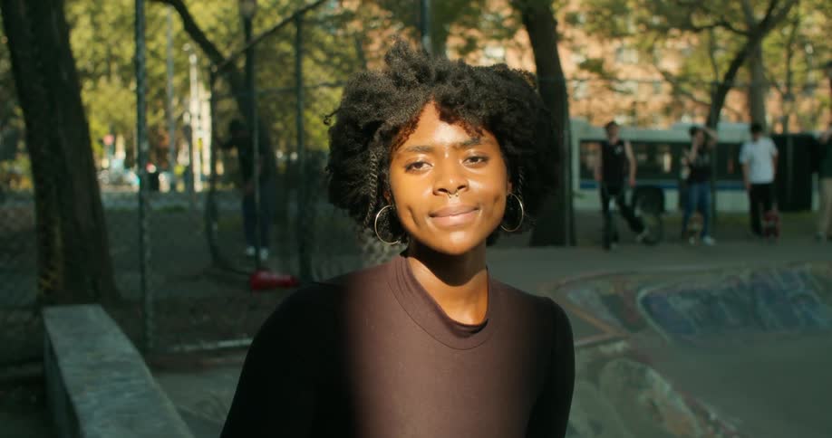 Portrait of a young woman smiling at a skateboard park