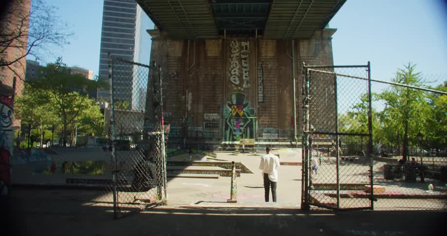 People skateboarding in a square below an overpass