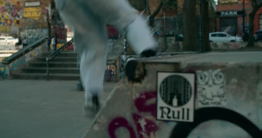 Woman doing tricks with a skateboard in an urban skate park