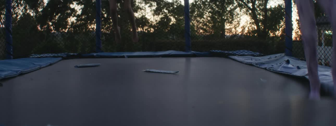 Children are jumping on the trampoline in the yard