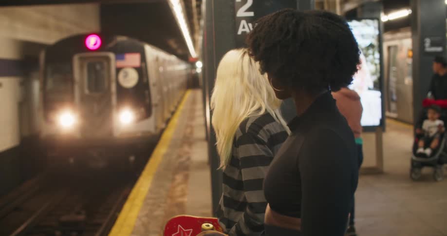People in a terminal waiting on the subway station platform