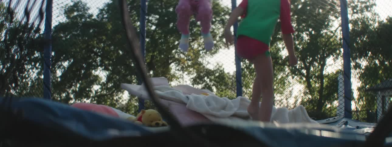 Two young girls have a blast jumping up and done on a trampoline