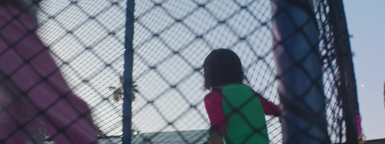 Two girls run around in a circles on a backyard trampoline
