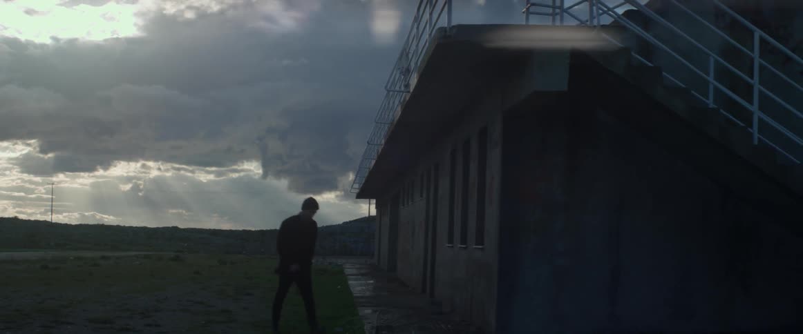 A man walks towards a rural building