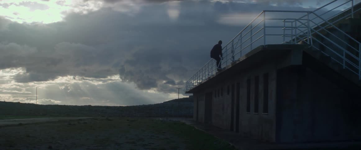 A man climbs from the roof of a building
