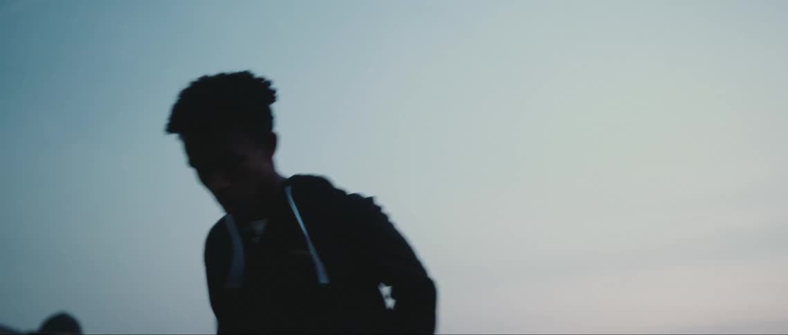 A black athlete runs vigorously in place outdoors