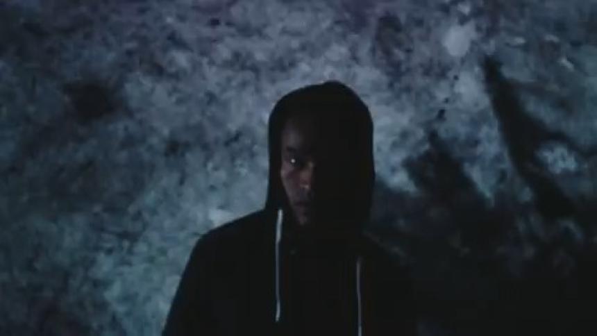 Portrait of a man in a hood with flashing lights in a dark environment