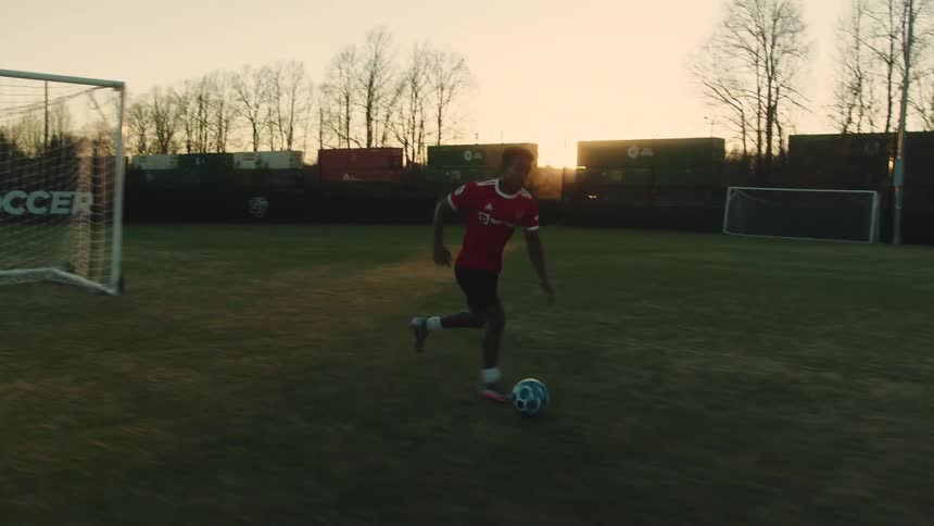 Boy running across the soccer field with the ball