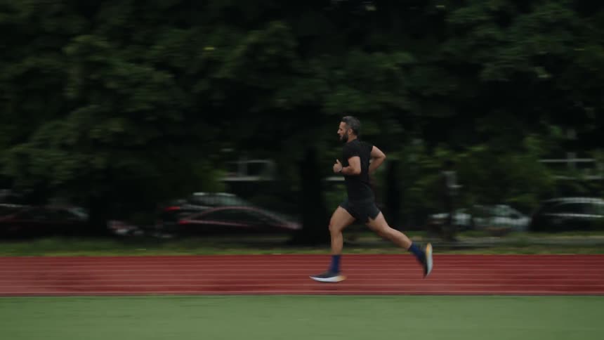 Man running on an athletics track in a park