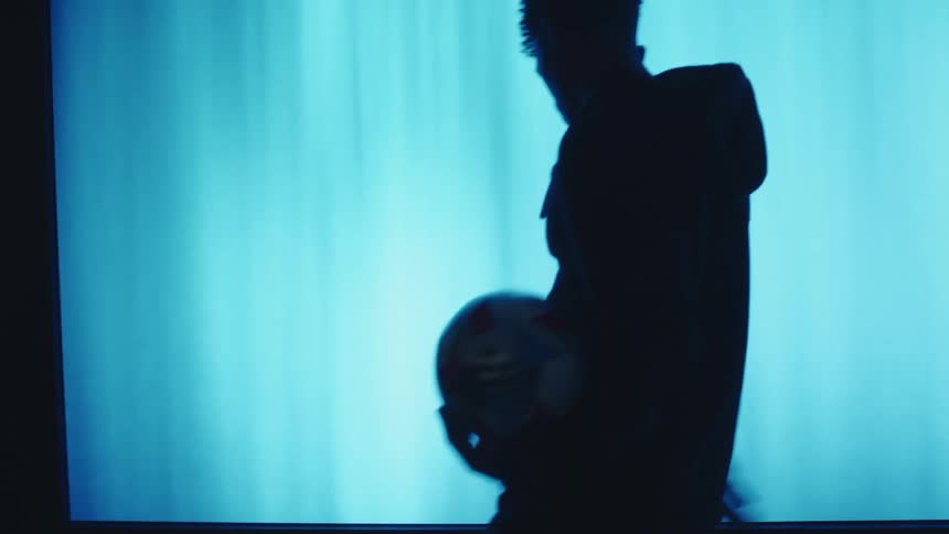 A black athlete on a stage holding a soccer ball