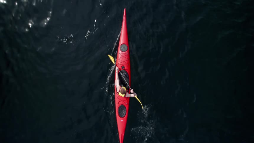 A man is paddling his kayak in the water