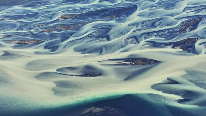 An aerial view of a region with sand and some lakes with blue water