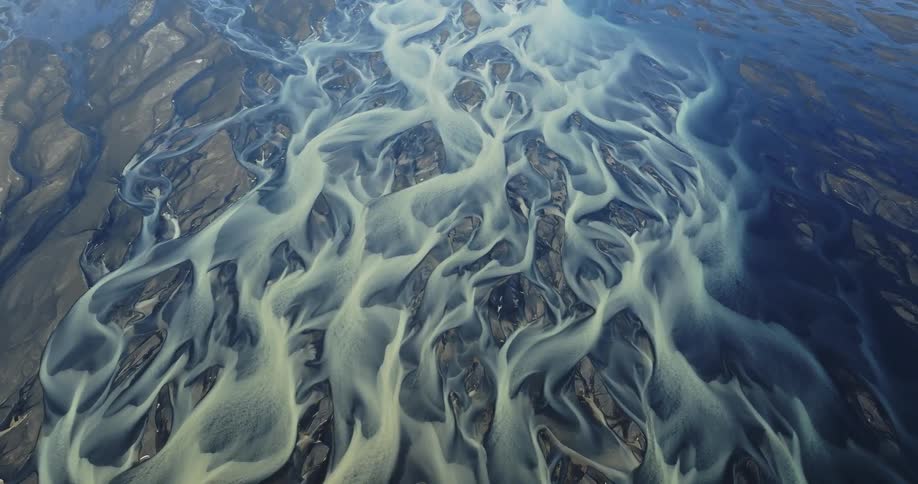 An aerial view of a region with several white smoky lines on the ground