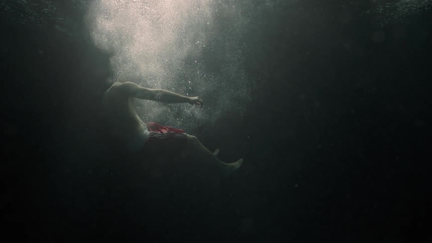 A white male drops into water and sinks