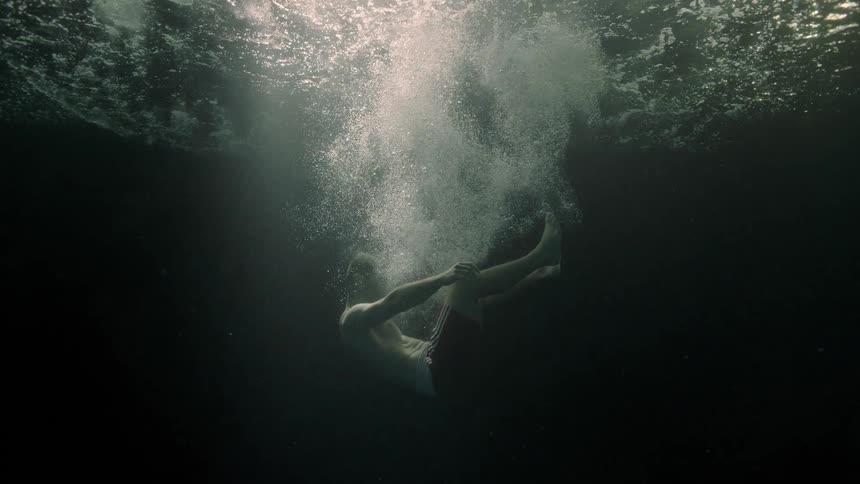 A man falls in the water and sinks