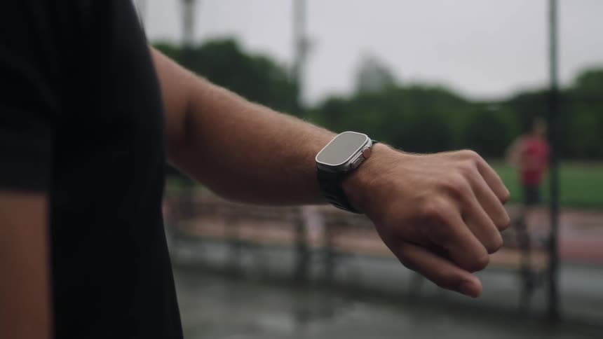 Man outdoors checking his smart watch on his wrist