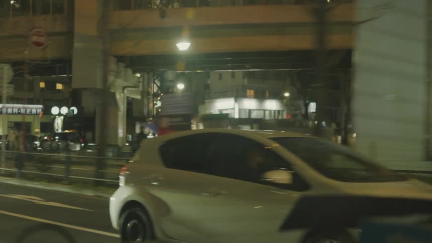 Traffic moves on the city street at night