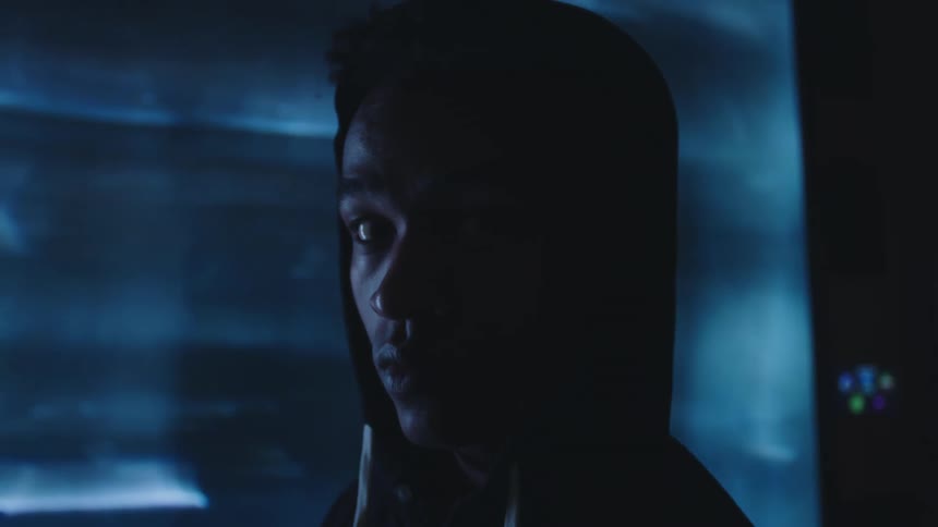Portrait of a man wearing a hood in a lowlight environment